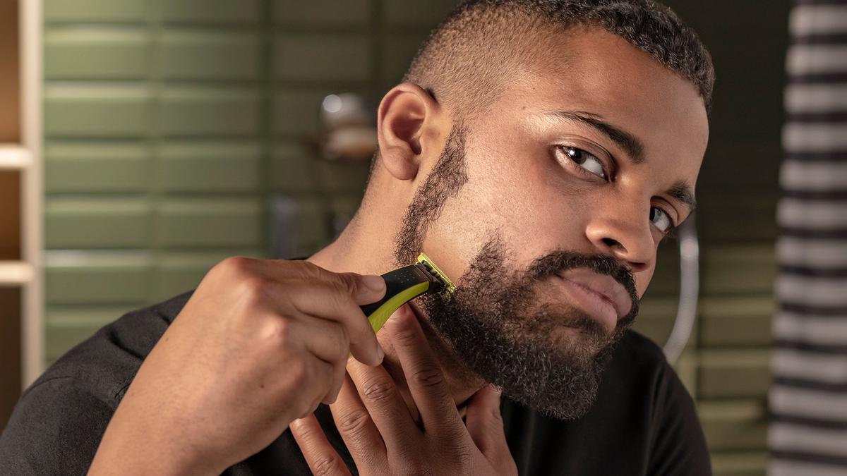 A man begins to shave his beard in preparation for Movember.