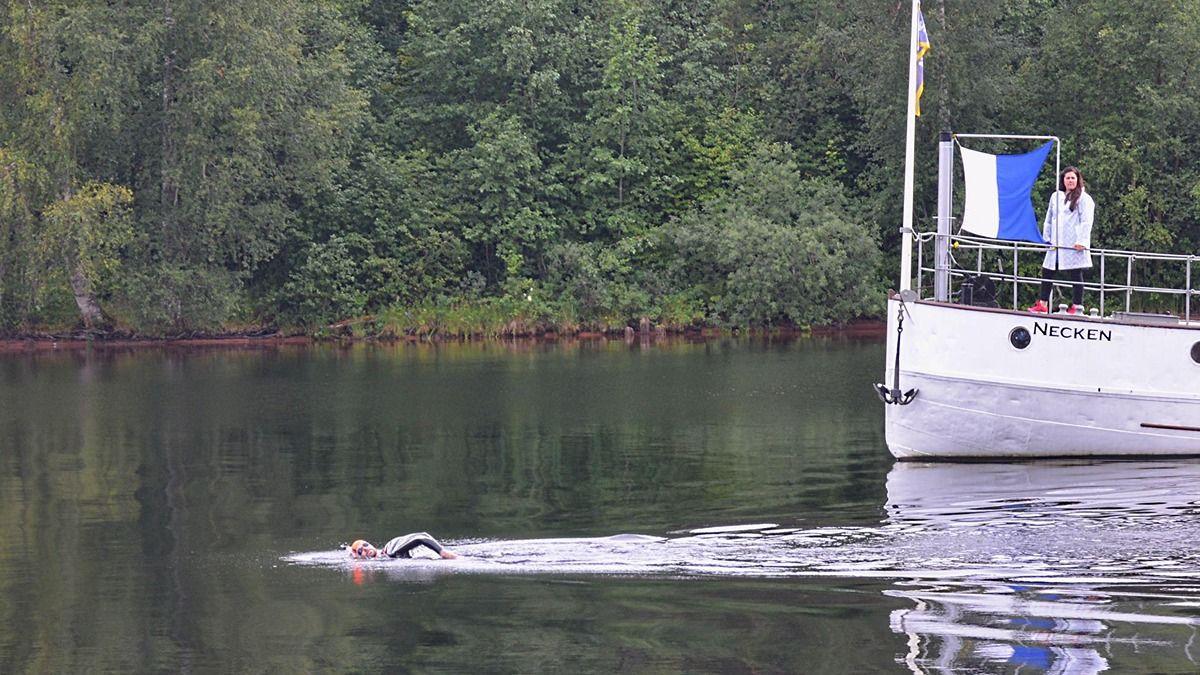 Pierre swimming in the water away from a boat