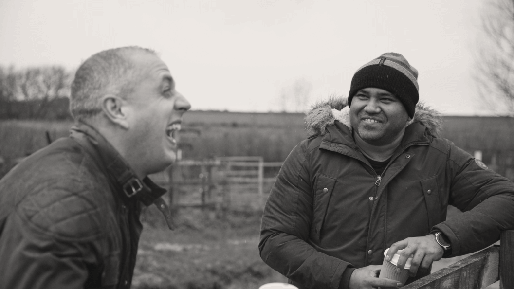 Two young men sharing a laugh while out walking in the country