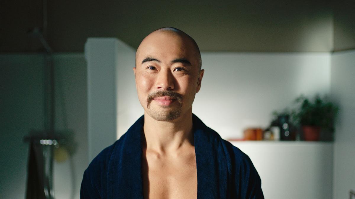 A man with a glorious moustache is in his bathroom, wearing a robe, getting ready to shave down for Movember