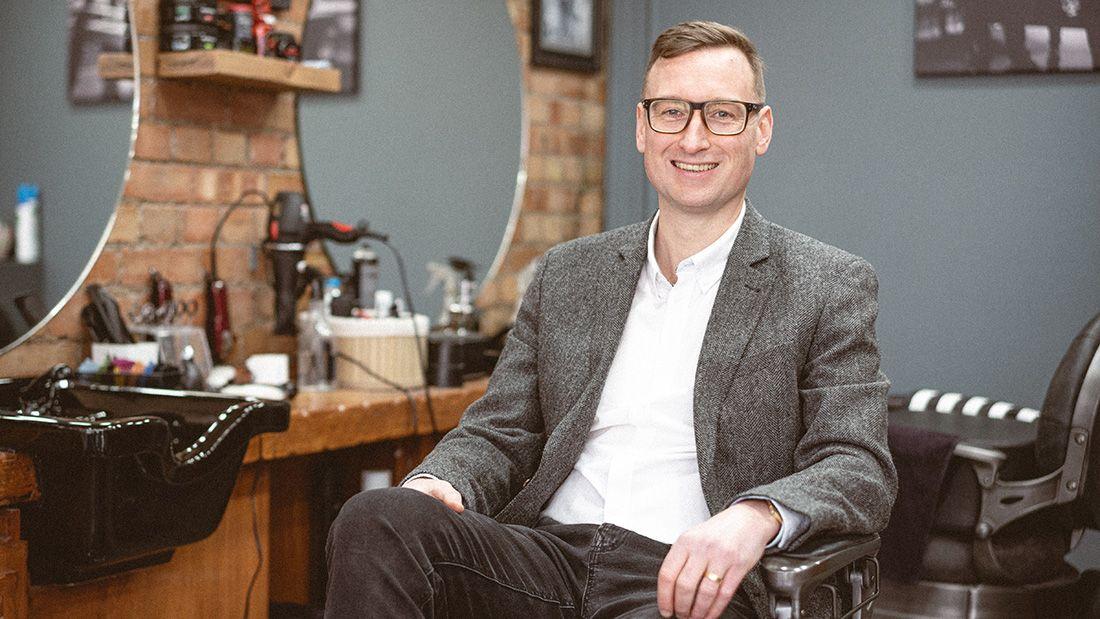 Peter in a barber chair in a barbers in oxford