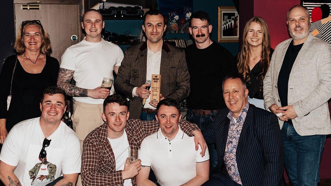 Mo Bros and Mo Sisters posing for a photo with their awards
