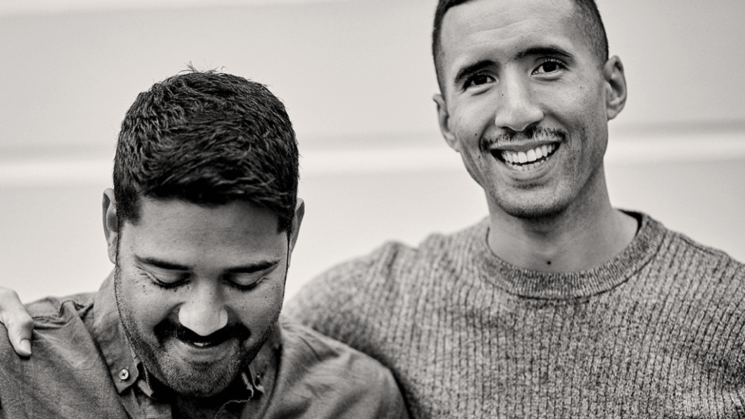 Two men smiling into camera