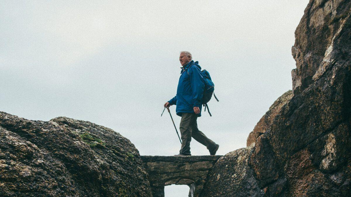 Older man hiking along a cliff