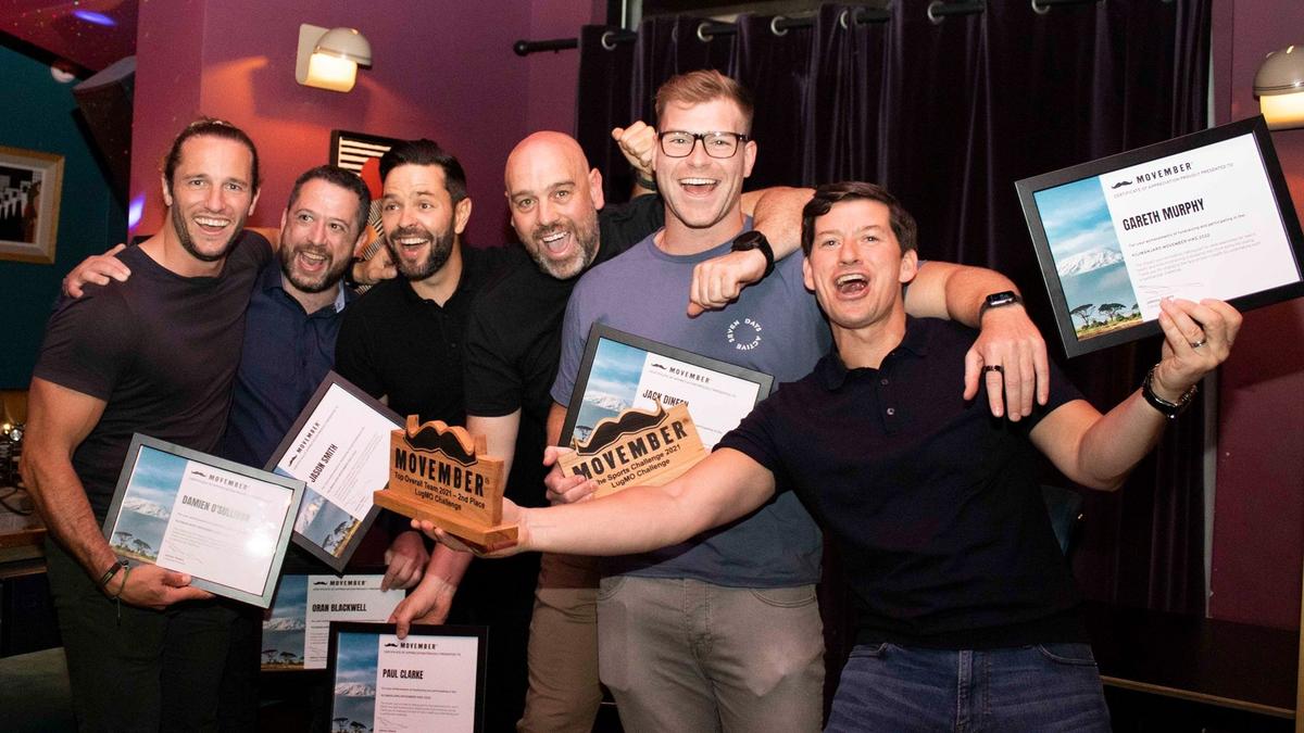 A group celebrating a win at an awards ceremony.