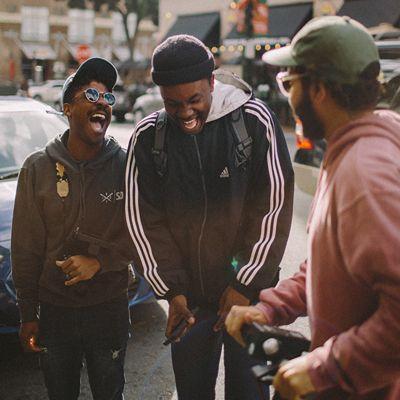 Three guys in the street talking and laughing 