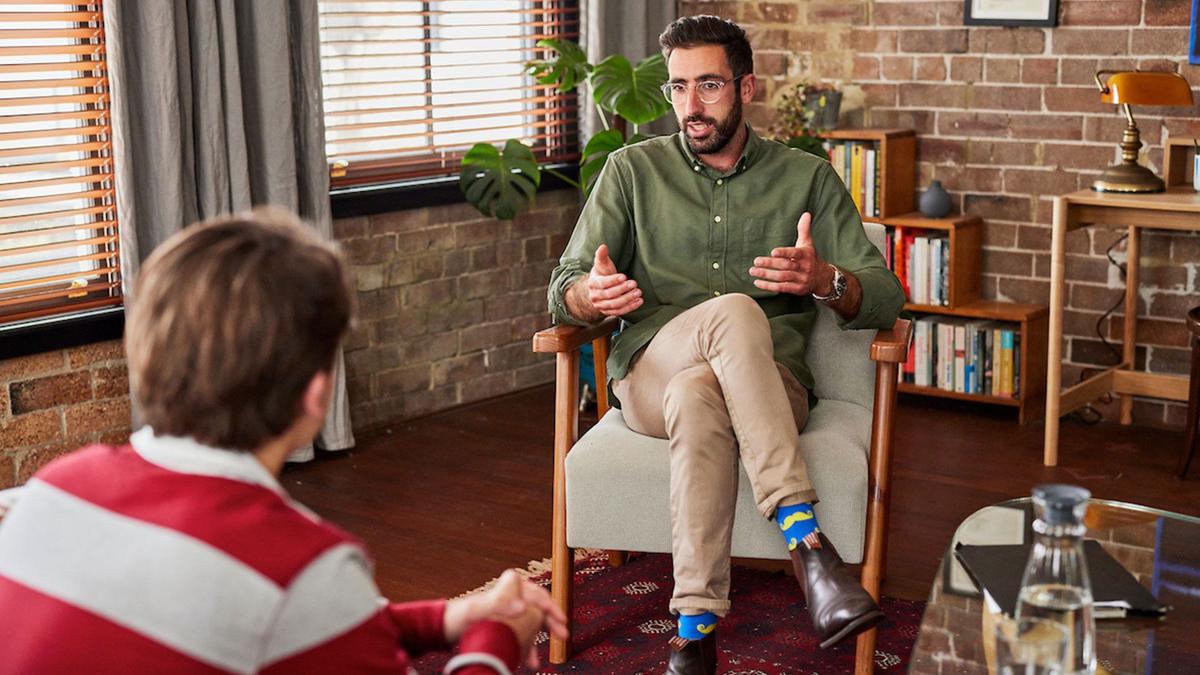 Dr Zac Seidler engaging with a male client during a therapy session