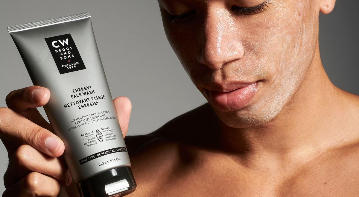 A man washing his face with a bottle of CW Beggs and Sons face wash.