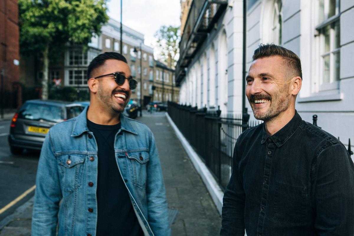 Two men standing in the street smiling