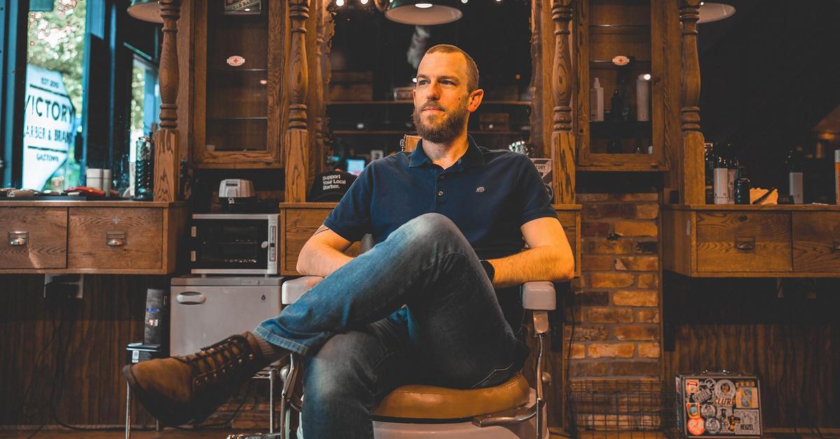 Mo Bro Rob Reid sits in a Vancouver barbershop chair, staring out the window