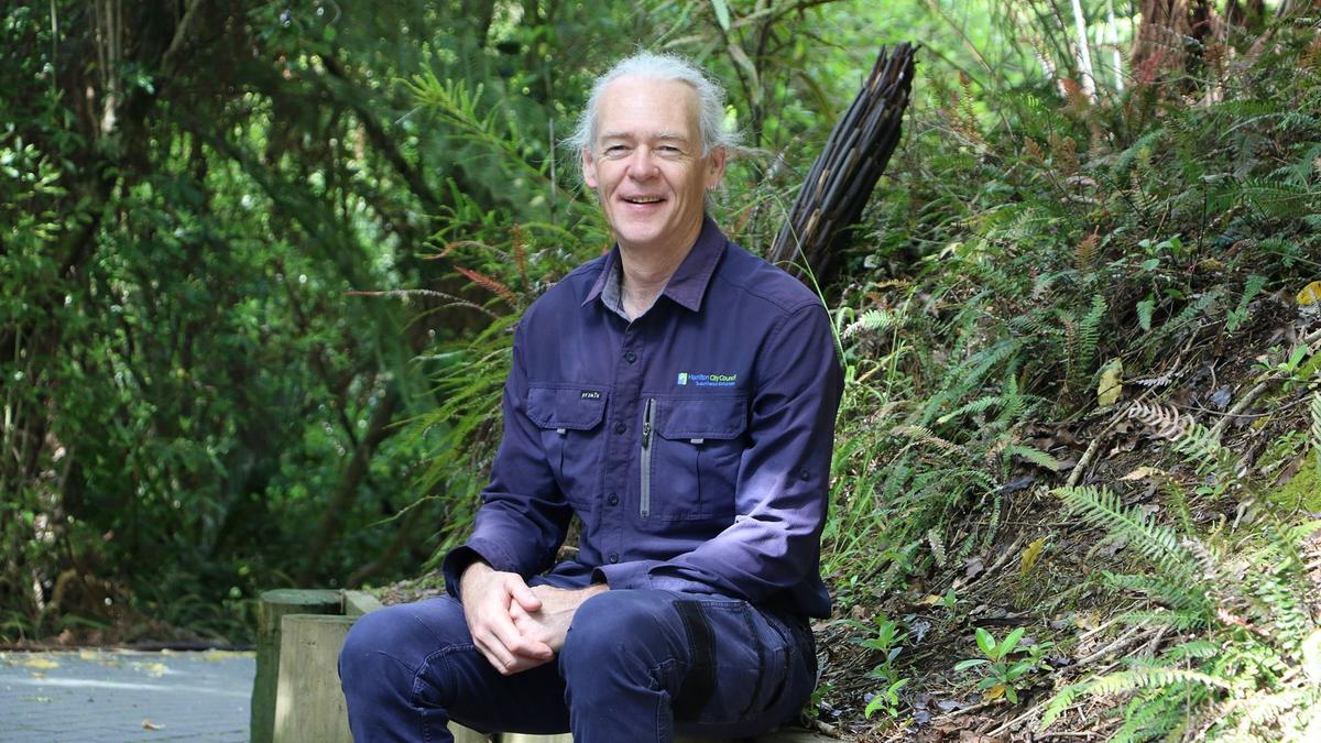 man sat on bench in garden 
