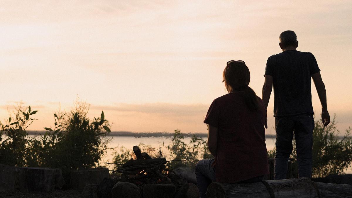 Silhouette of a man and a woman with sunset behind them