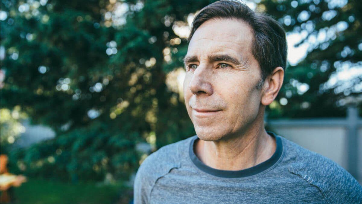 Older man in grey top outdoors