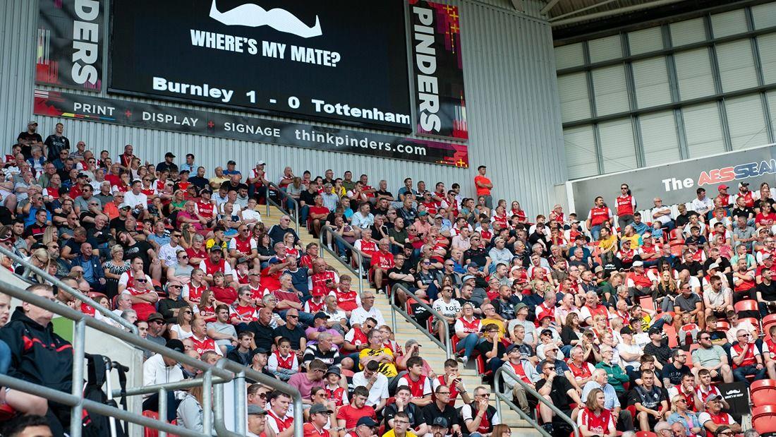 A full football stadium with a big banner saying 'where's my mate?'