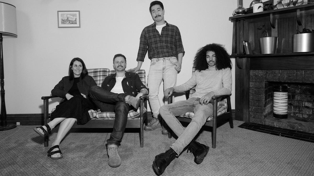 A photo of a Mo Sister and three Mo Bros sitting together in a living room.