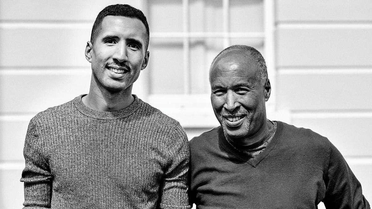 A black and white photo of a father and son standing together