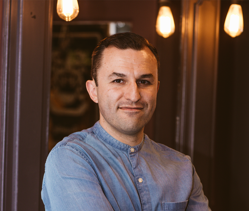 A man standing with his arms crossed looking directly at the camera