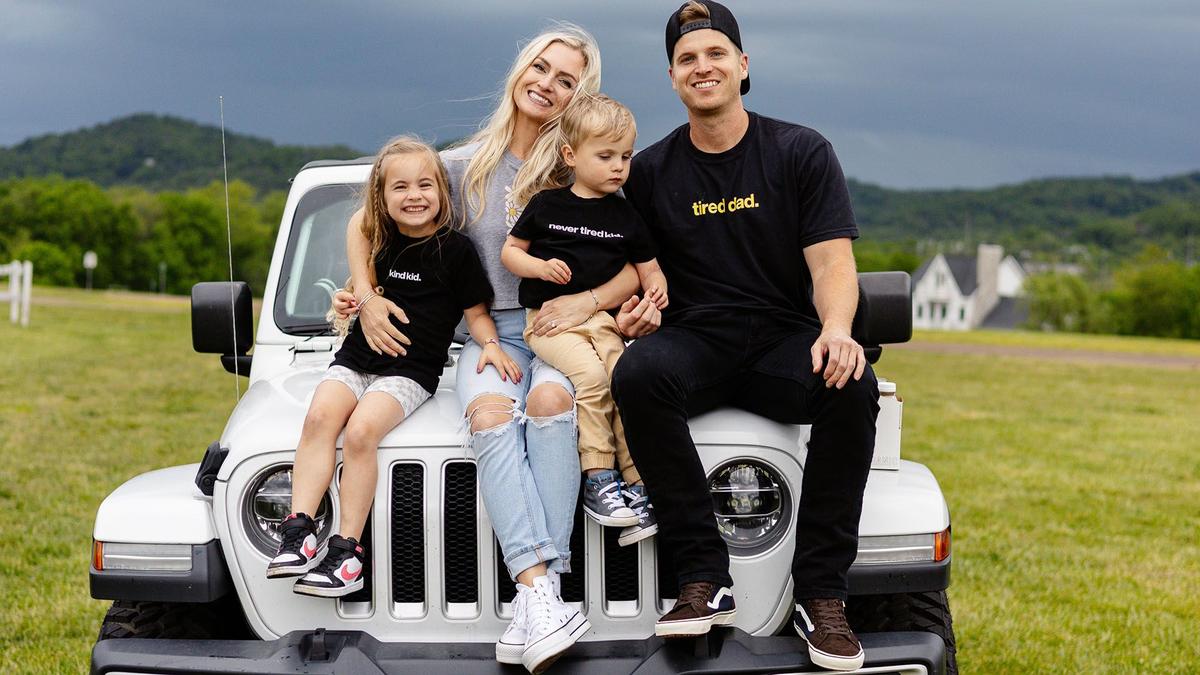 Young father smiling to camera with his adoring family. 