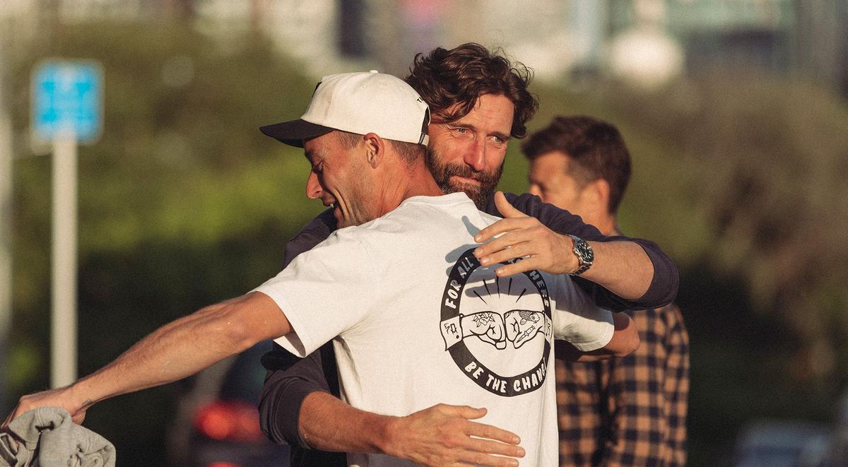SpeakEasy male participants embrace.