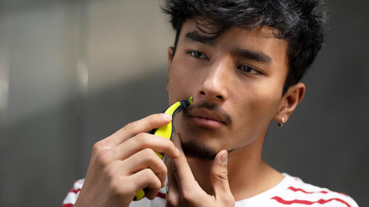 A man grooms his stylish moustache that he's grown for Movember