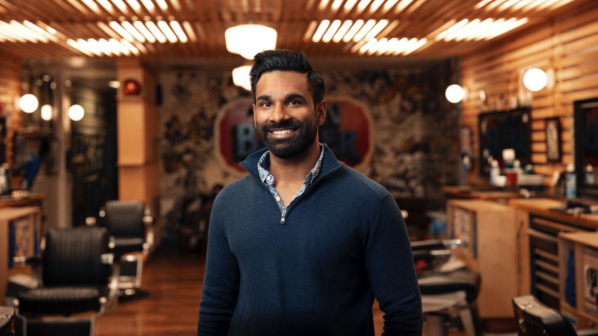 Man in barbershop smiling to camera