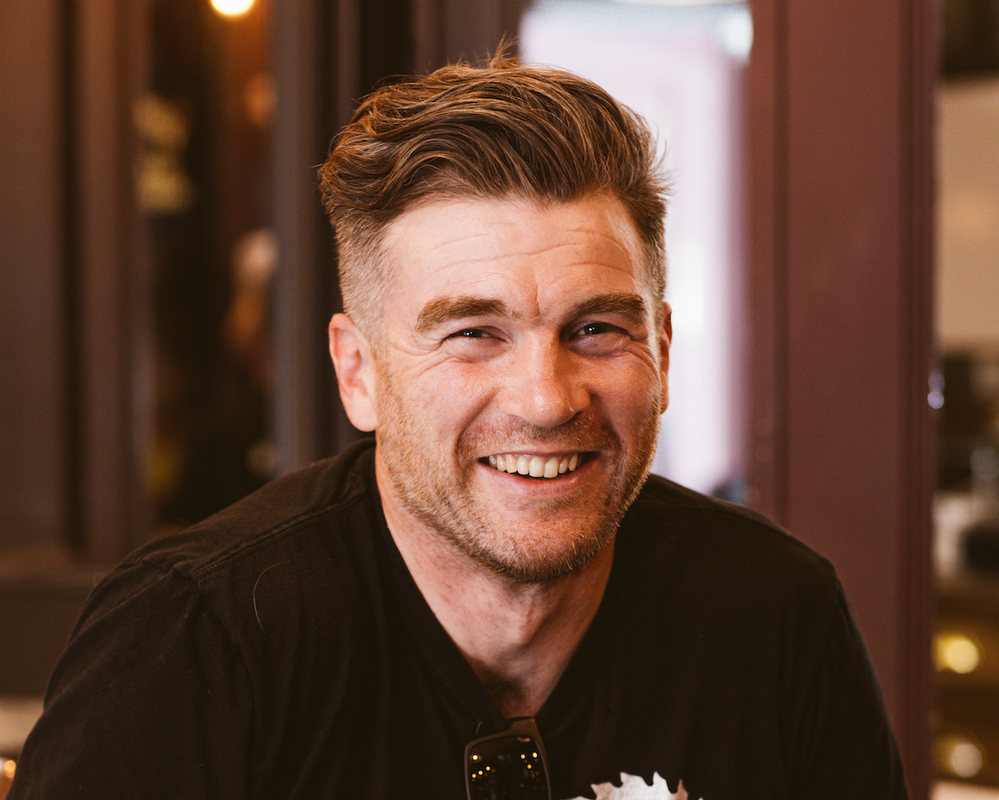 A man is smiling directly at the camera 