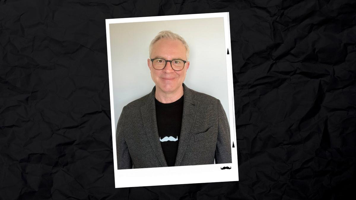 Man with glasses on polaroid photo with black background
