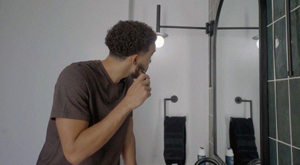 Man shaving down with a Gillette razor in a mirror