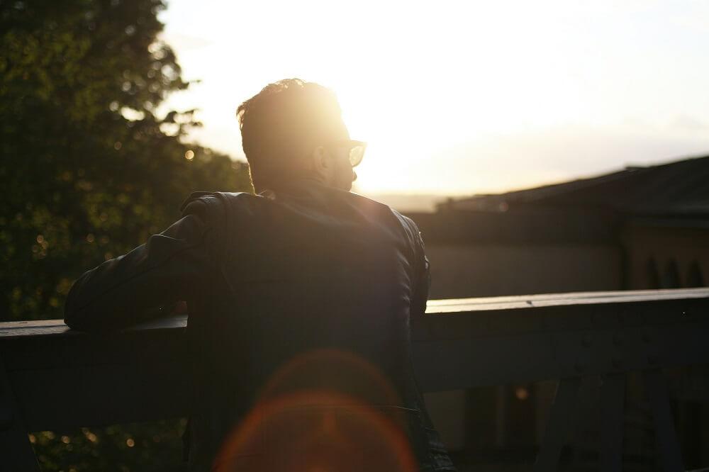 A man standing outside at sunset 
