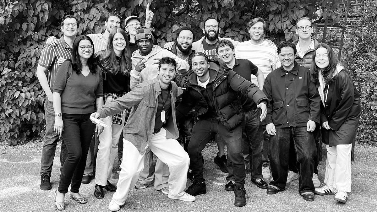 Black and white photo showing a group of young people smiling to camera.