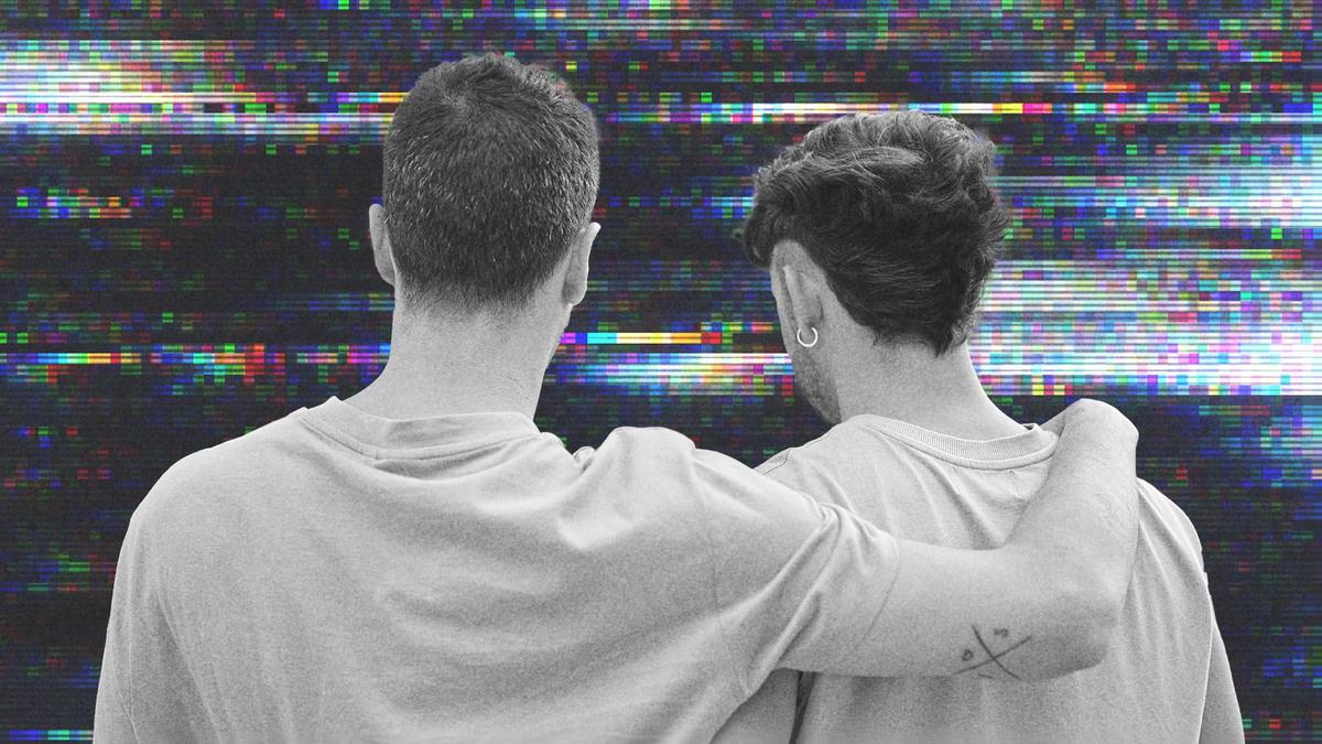Two men standing with their arm around each other.