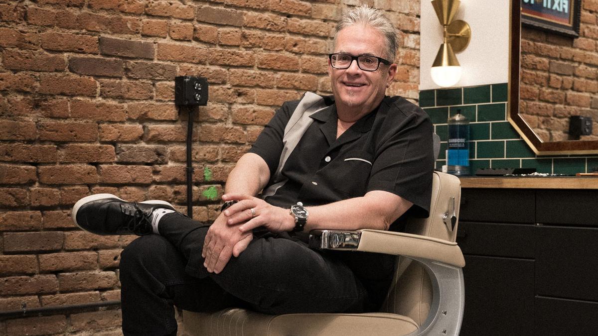 Mo Bro Jeff smiles for the camera from a classic barbershop chair in Denver