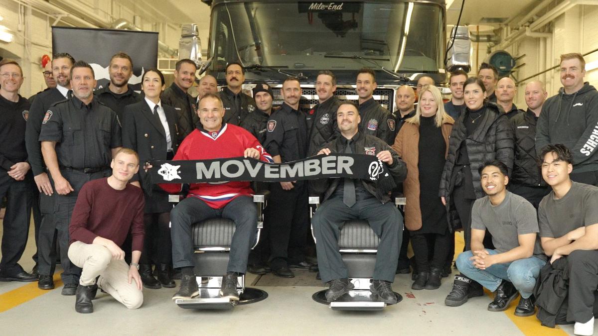 A group of Movember fundraisers pose in a fire hall