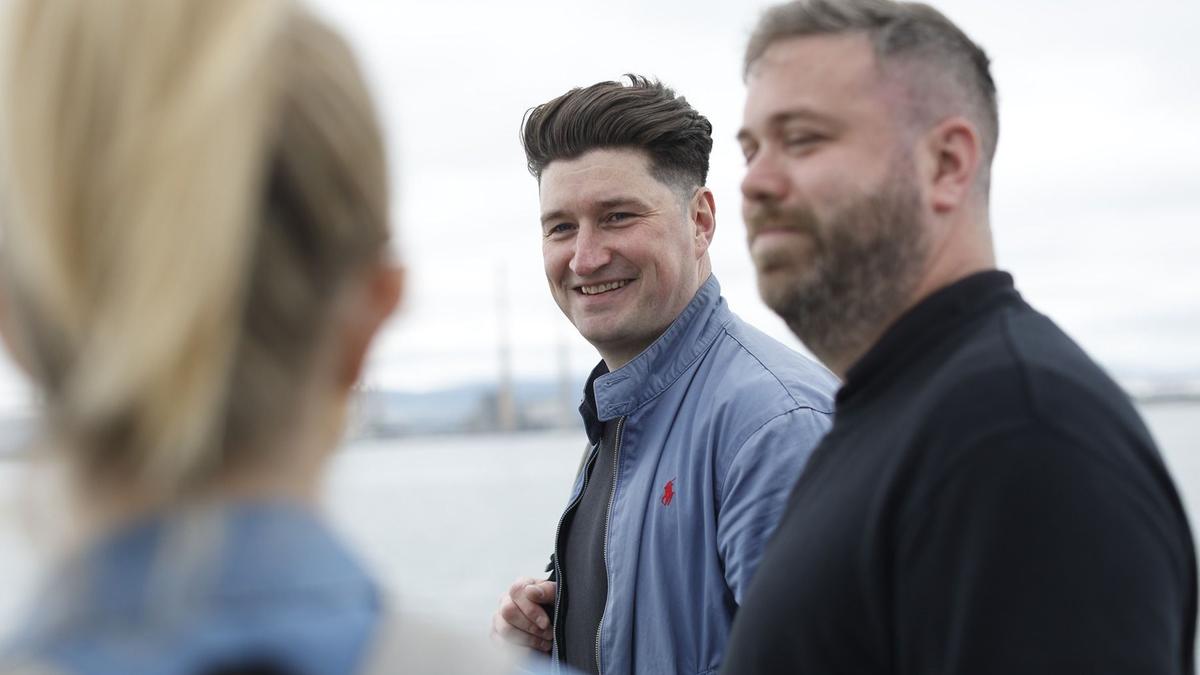 2 men standing and talking and smiling