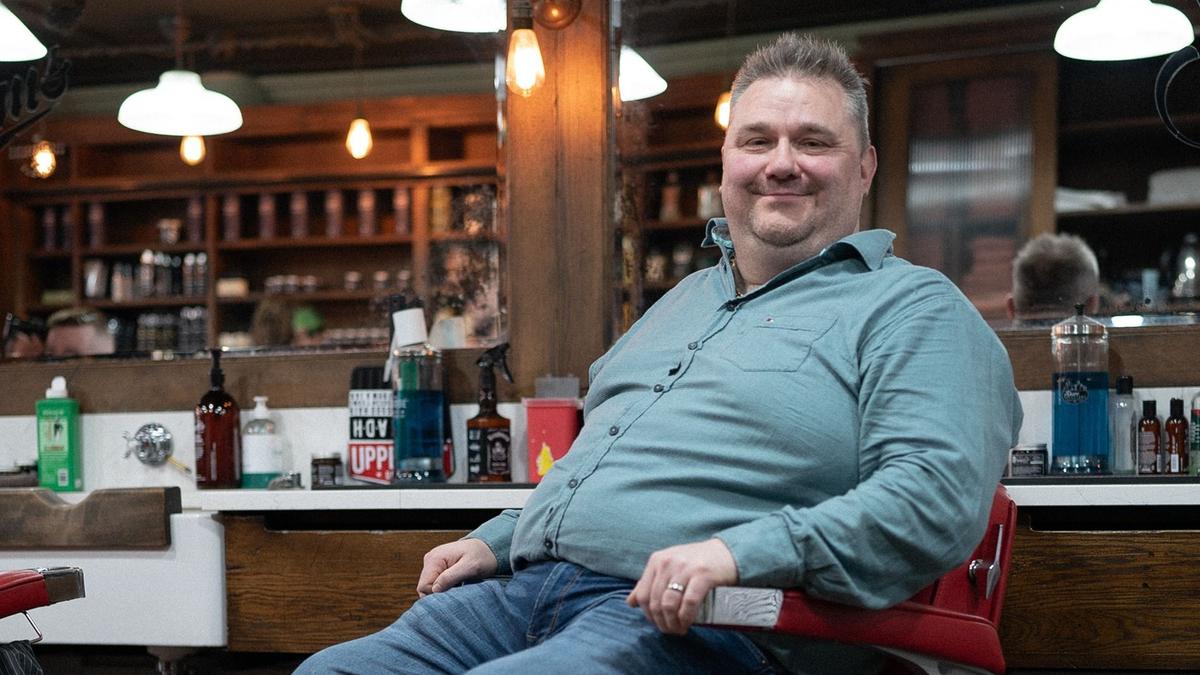 Jen sitting in a barber smiling at camera
