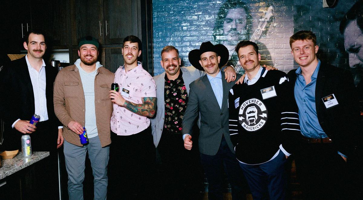 A group of men arm in arm at an event