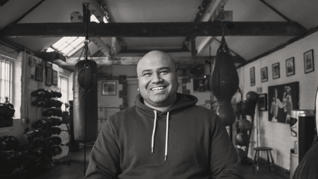 Man sitting inside a boxing gym