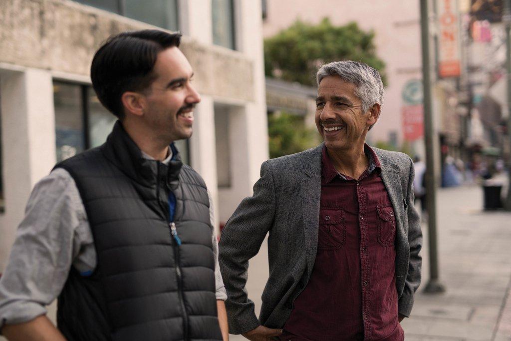 Two guys talking and smiling in the street