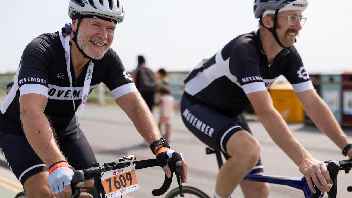 Stephen and a friend cycling wearing their Movember kit