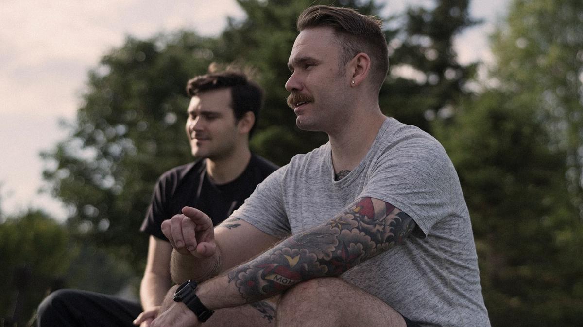 Two men sitting together in nature