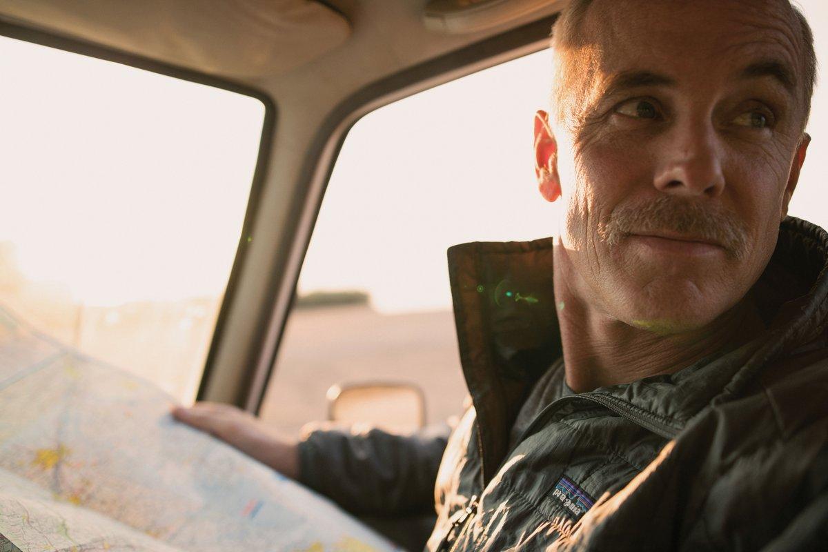 Middle age man sitting in a car with a map
