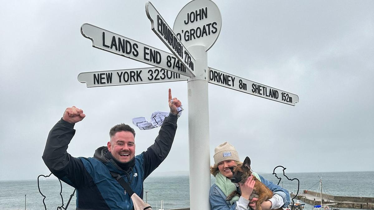 Cam stood next to a sign saying John O'Groats