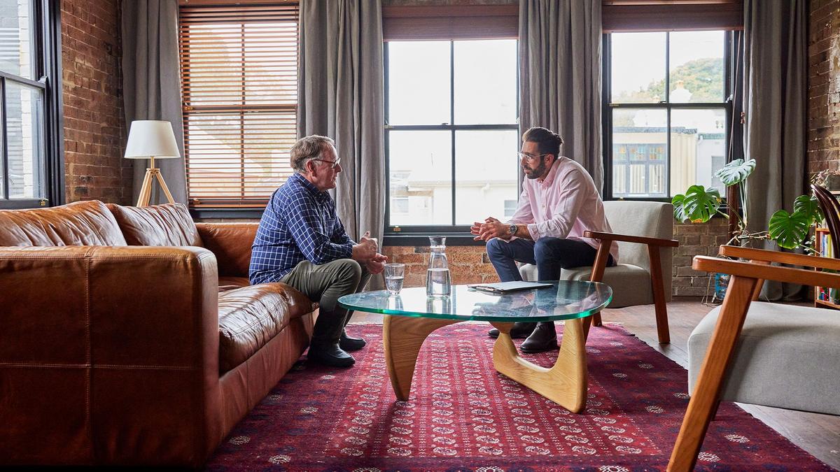 Two men sit in a therapy office