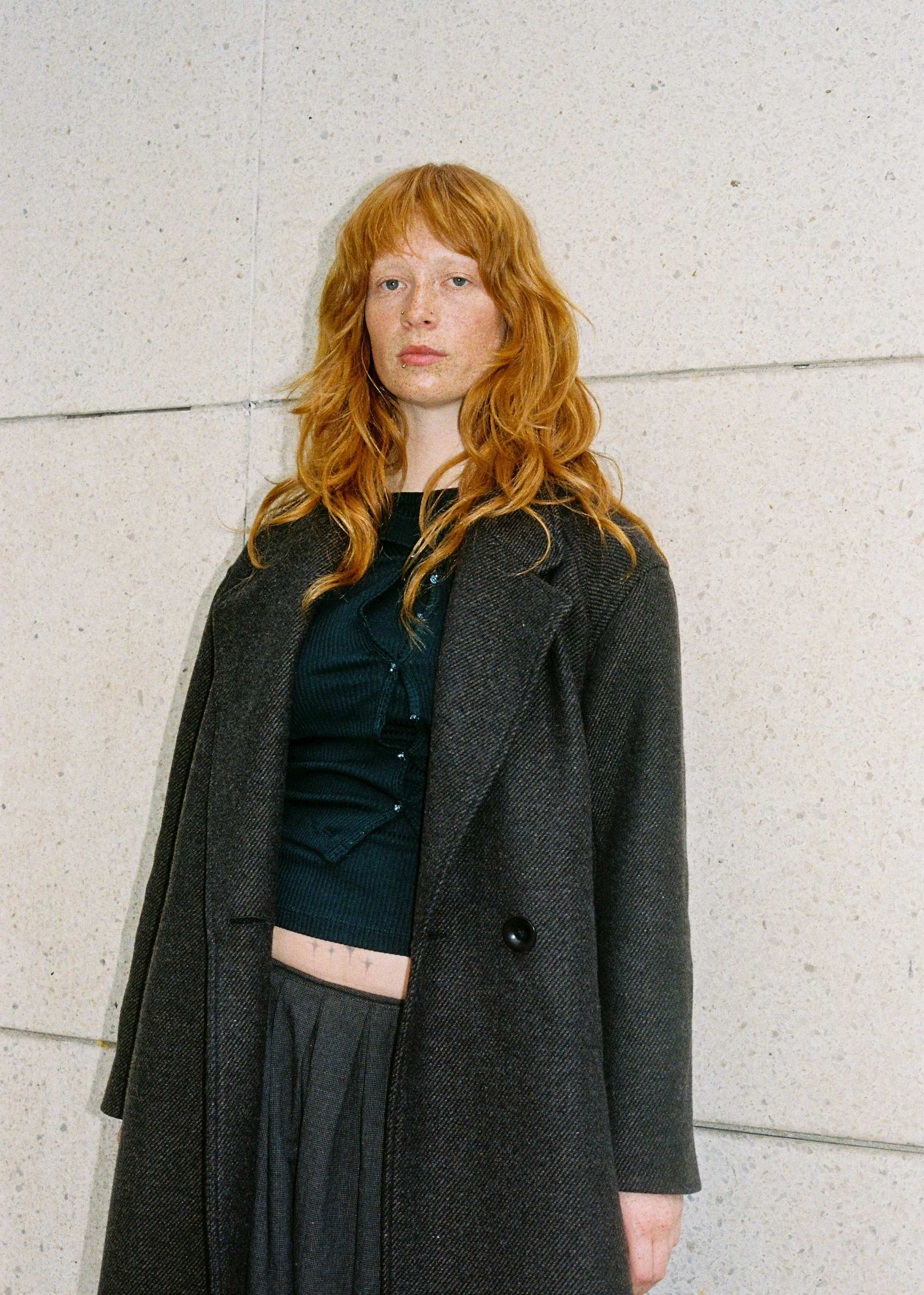 Model with red hair wearing a dark brown wool coat