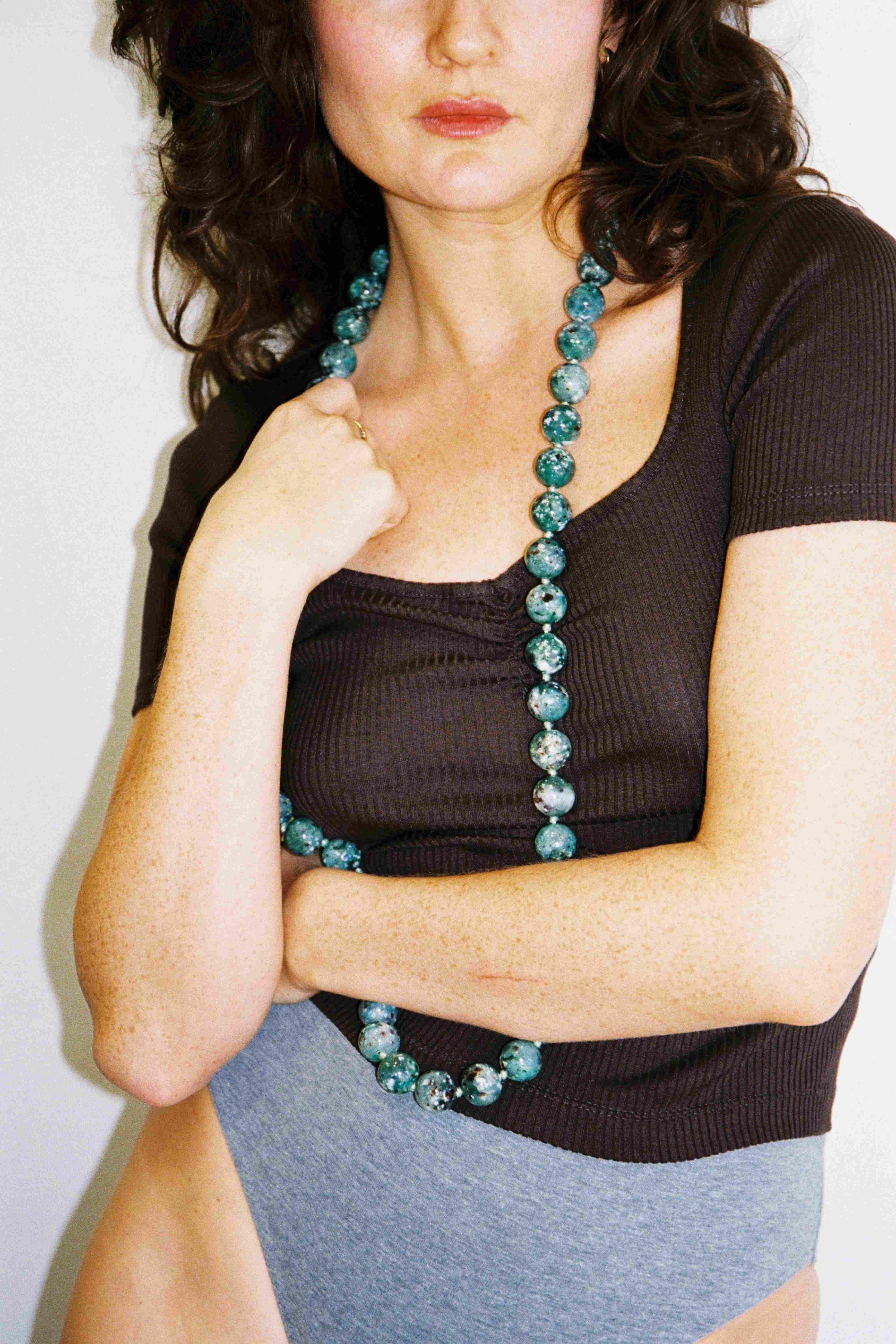 Model wearing cocoa Swan tee with jade beads