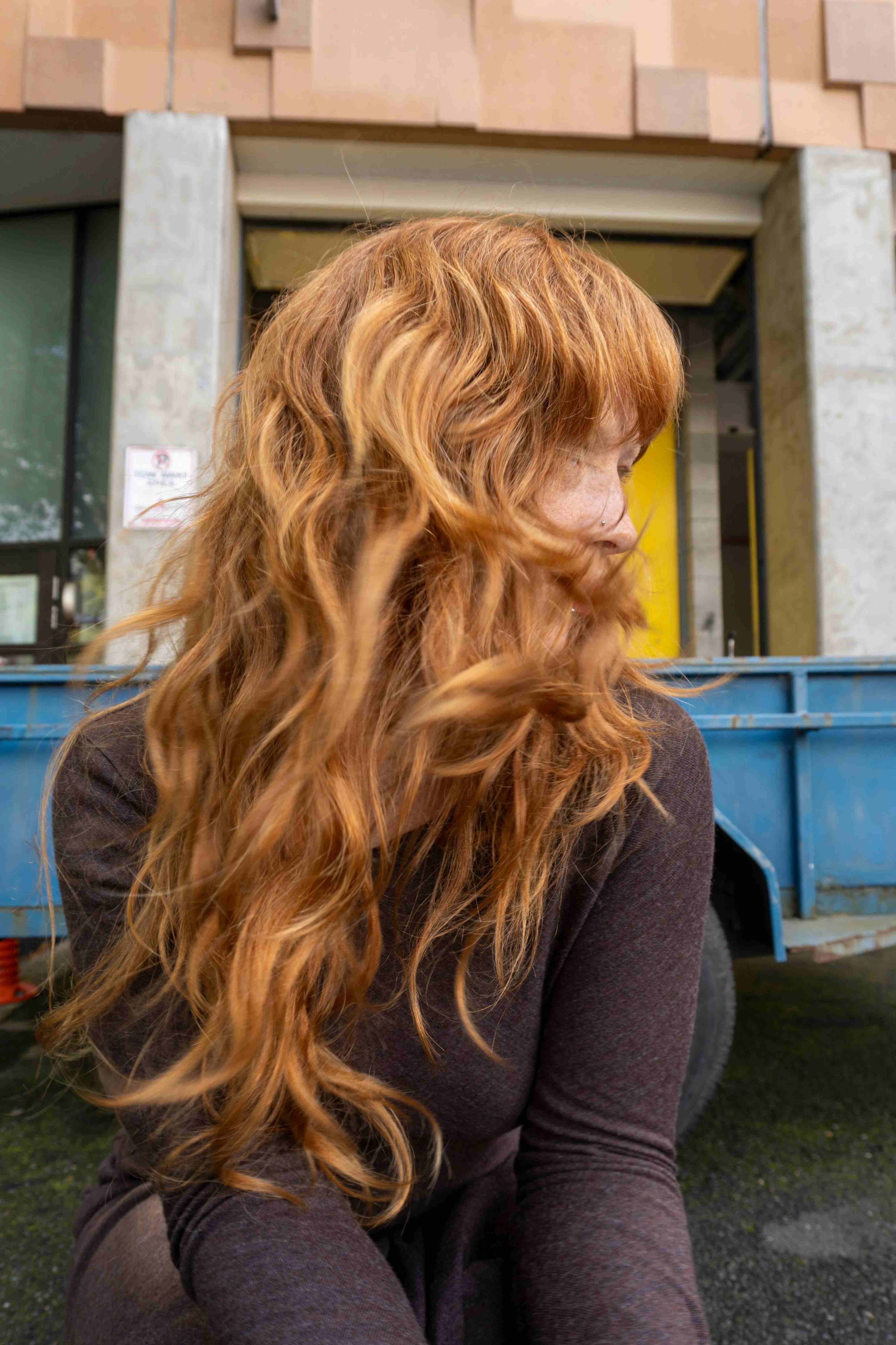 Model wearing a Raisin Melange Serafina top and swishing their hair 