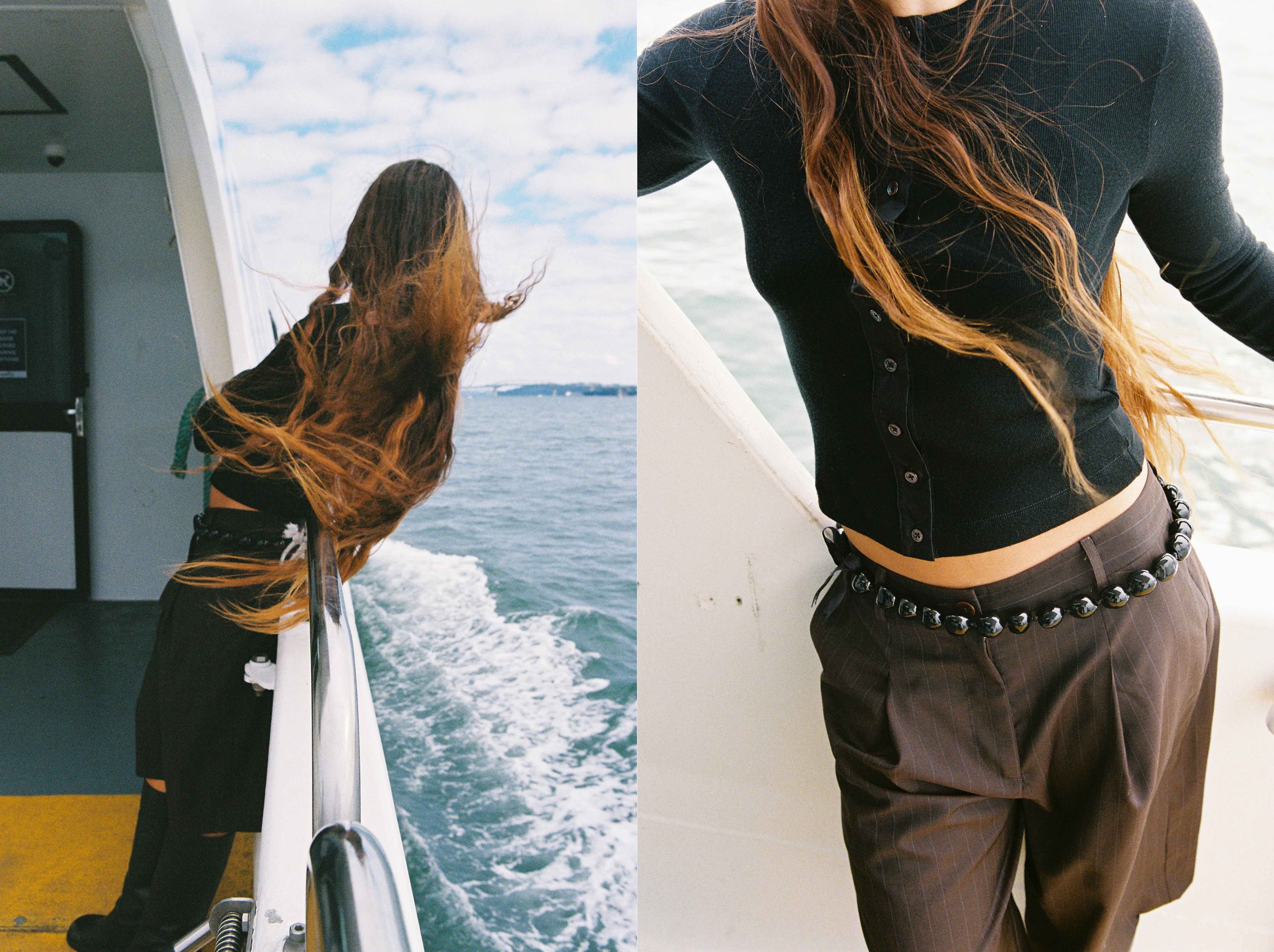 Woman with long hair leaning over moving ferry
