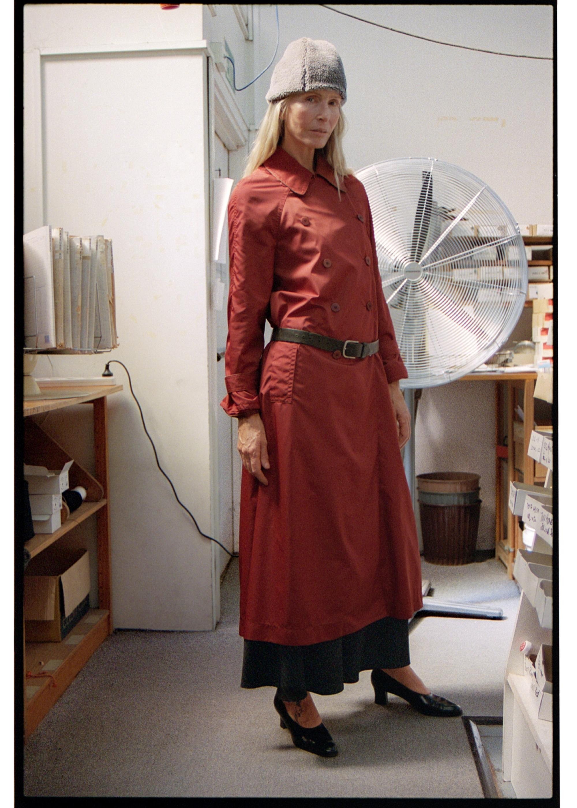 Model wearing Red raincoat in a workroom