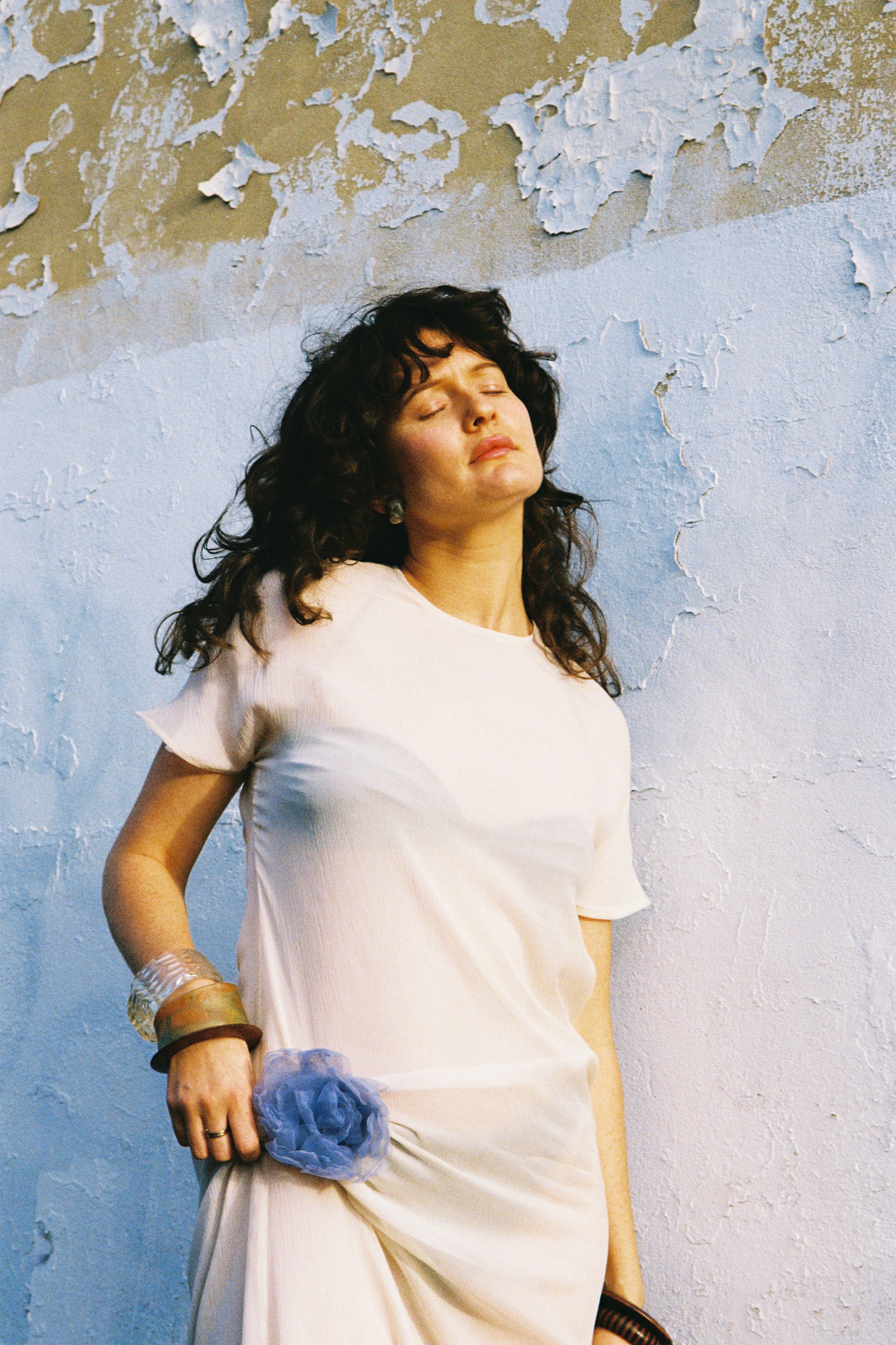 Model wearing cocoa brown knit tee and large stone necklace
