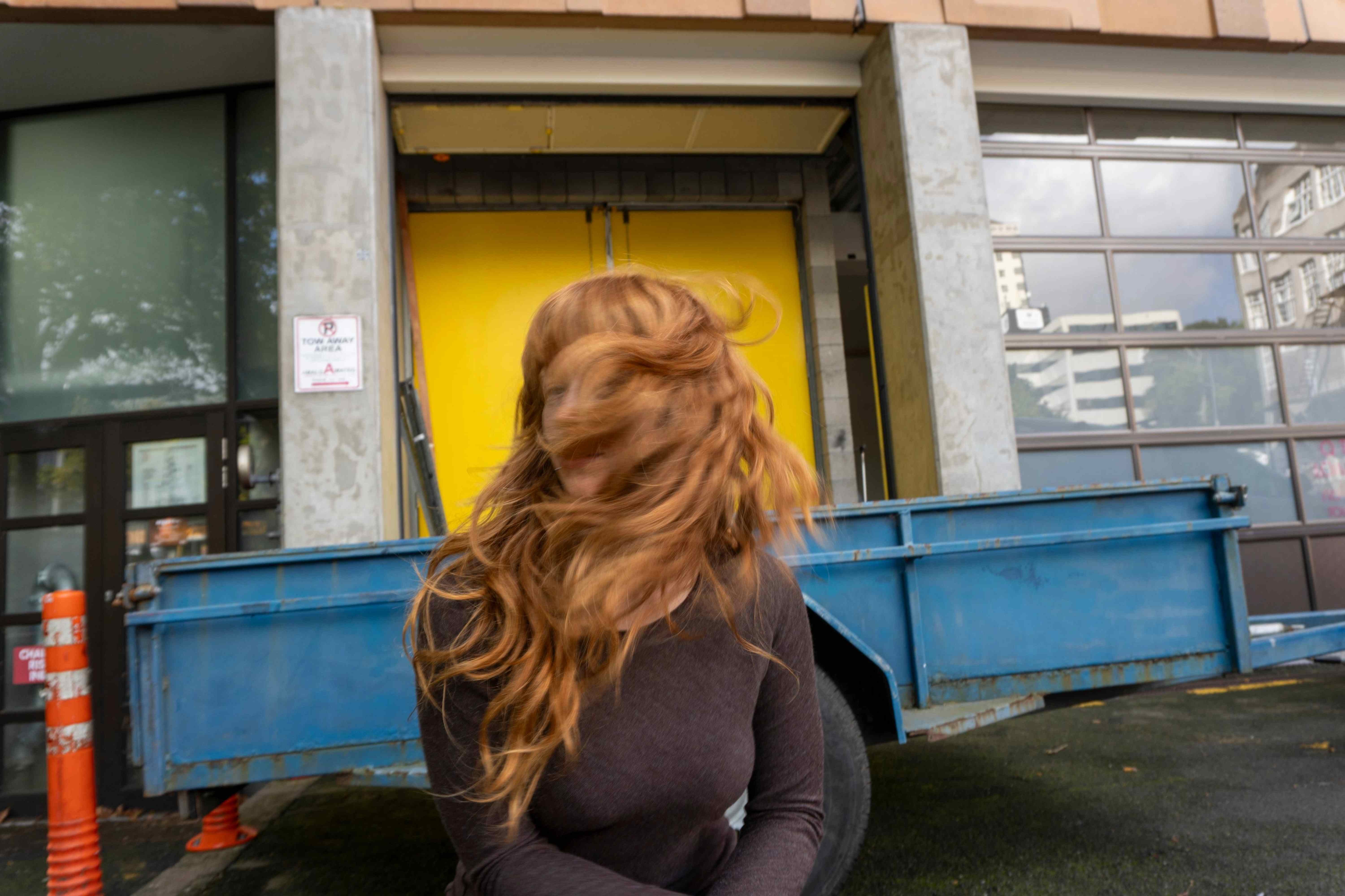 Model wearing a Raisin Melange Serafina top and swishing their hair 